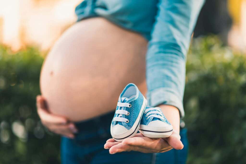 Bienfaits de la relaxation guidée : flou artistique des chaussures de bébé dans les mains d'une future maman