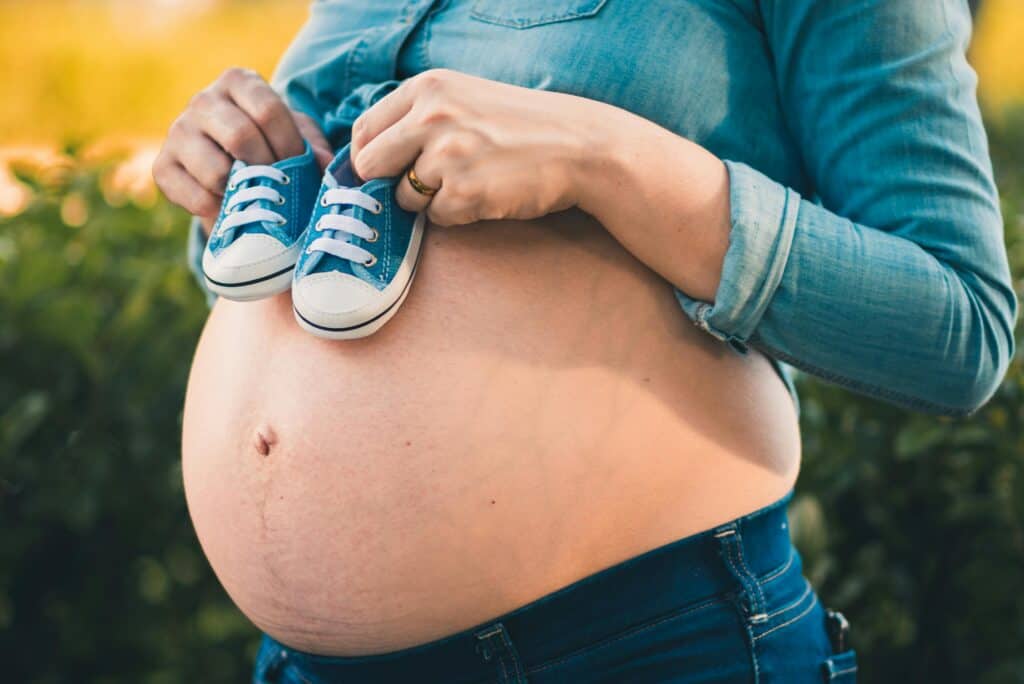 Relaxation guidée pour femmes enceintes : femme enceinte tenant des petites chaussures de bébé