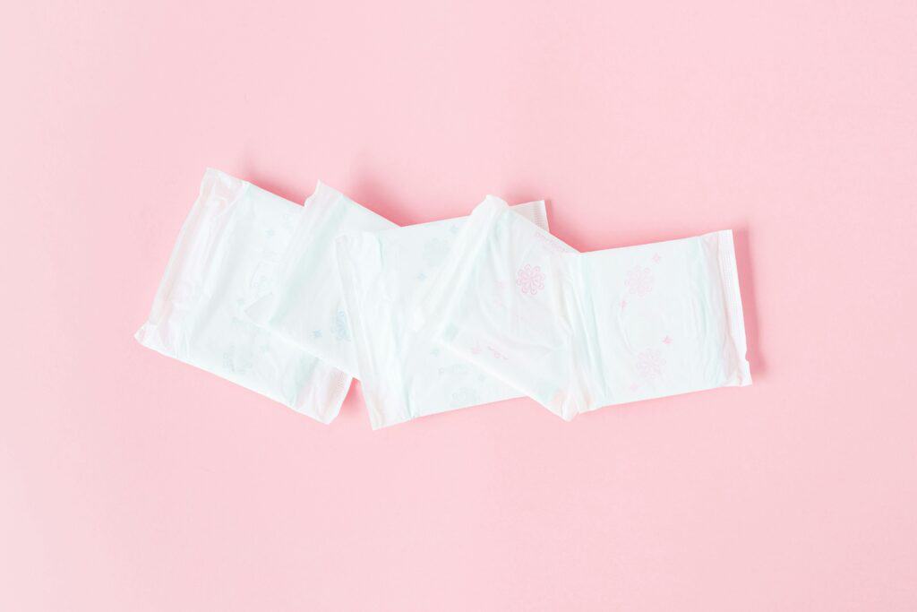 Serviettes menstruelles jetables sur fond rose, une solution classique pour les règles douloureuses