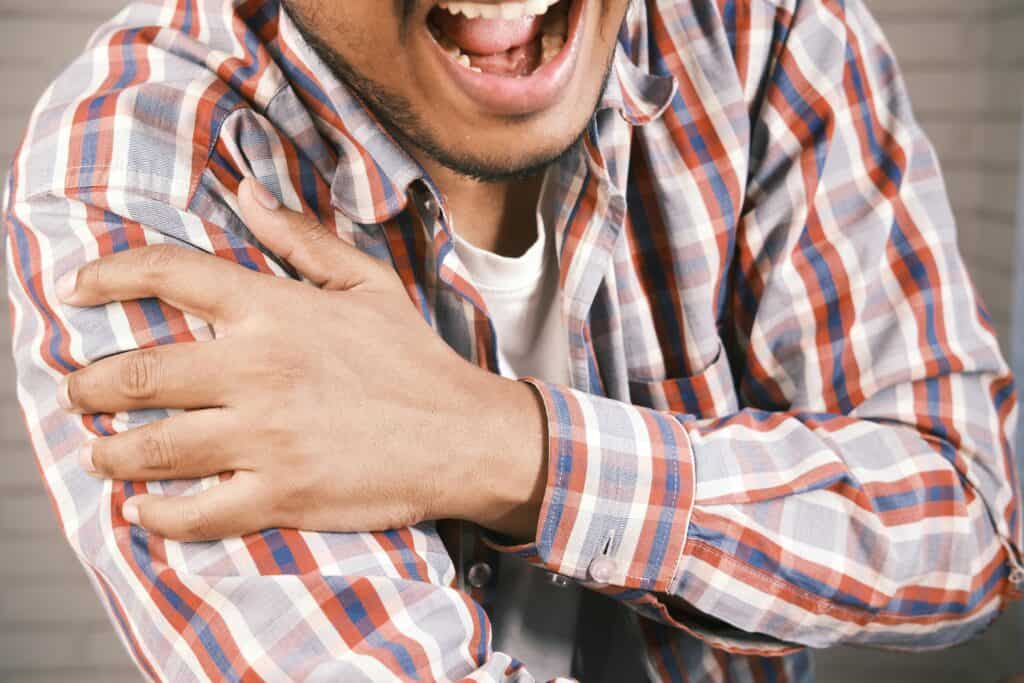 Homme ressentant une douleur à l’épaule, illustrant l’impact de l’arthrite sur les articulations